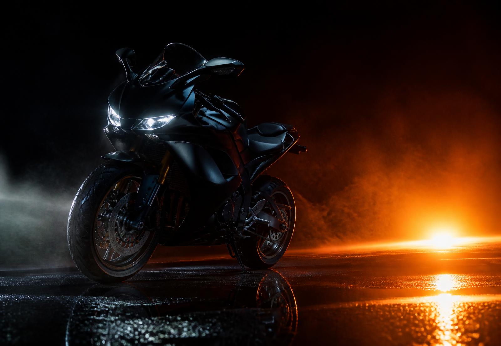 Moto sportive éclairée de nuit sur asphalte mouillé